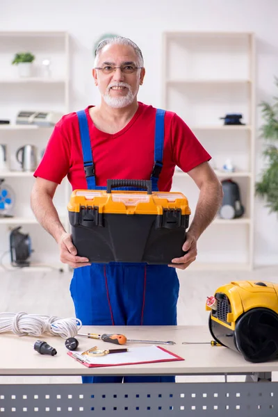 Alte männliche Auftragnehmer reparieren Haushaltsgeräte im Haus — Stockfoto