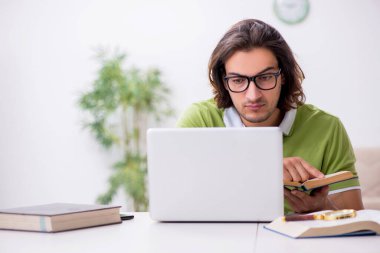 Evde sınava hazırlanan genç bir erkek öğrenci.