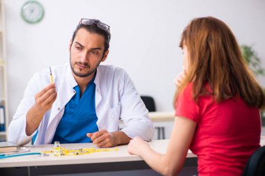 Bayan şeker hastası genç erkek doktoru ziyaret ediyor.