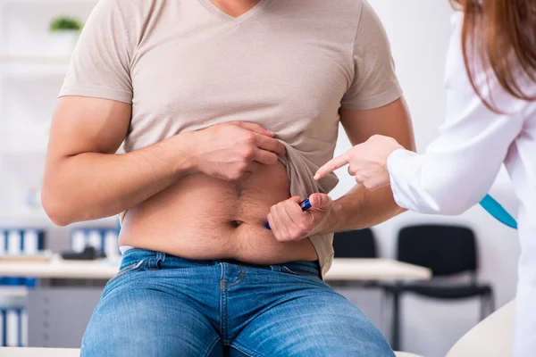 Paciente diabético masculino que visita a una joven doctora —  Fotos de Stock