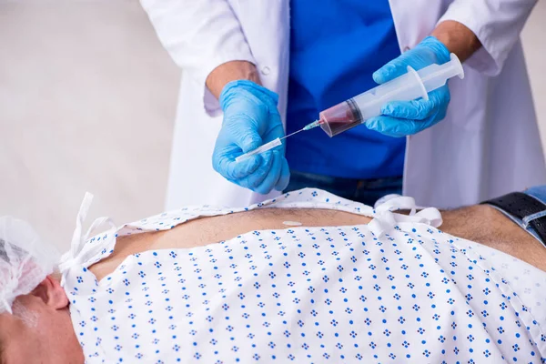 Velho visitando jovem médico estagiário — Fotografia de Stock