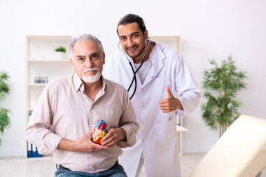 Yaşlı adam genç doktor kardiyoloğu ziyaret ediyor.