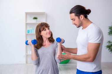 Kişisel koçla spor egzersizleri yapan genç bir kadın.