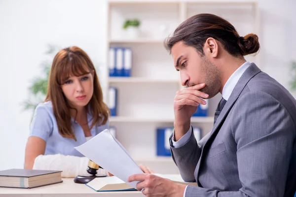 Jonge gewonde vrouw en mannelijke advocaat in de rechtszaal — Stockfoto