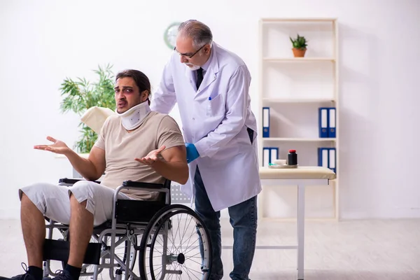 Young face injured man visiting experienced male doctor traumato — Stock Photo, Image
