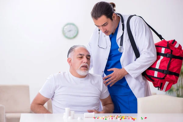 Jeune homme médecin visitant vieux patient masculin à la maison — Photo