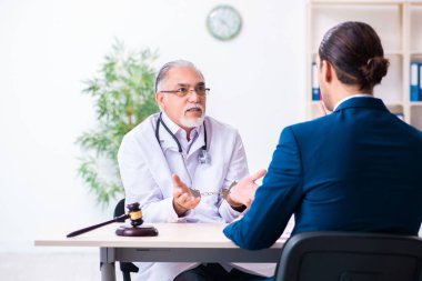 Adliyedeki erkek doktor avukatla toplantıda.