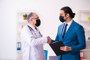 Genç işadamı yaşlı doktorla görüşüyor.
