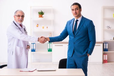 Genç işadamı yaşlı doktorla görüşüyor.