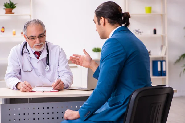 Young businessman meeting with old doctor — Stock Photo, Image