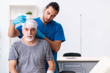 İlk yardım konseptinde genç erkek doktor ve yaşlı hasta.