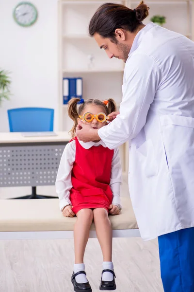 Klein meisje op bezoek bij jonge mannelijke arts oculist — Stockfoto