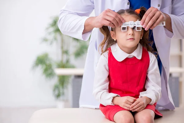 Klein meisje op bezoek bij jonge mannelijke arts oculist — Stockfoto