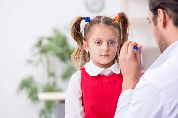 Klein meisje op bezoek bij jonge mannelijke arts oculist — Stockfoto