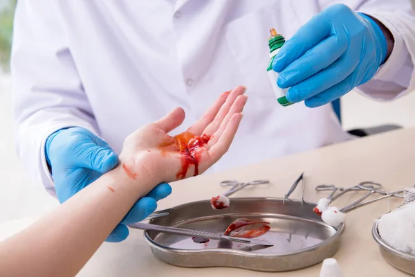 Mano lesionada mujer visitando doctor masculino — Foto de Stock