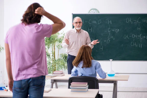 Oude scheikundeleraar en twee leerlingen in de klas — Stockfoto