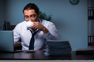 Gece ofiste çalışan genç bir erkek.