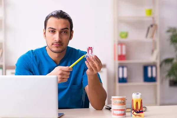 Jovem dentista do sexo masculino que trabalha na clínica — Fotografia de Stock