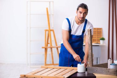 Genç erkek müteahhit atölyede çalışıyor.