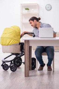 Genç baba yeni doğan bebeğe evde bakıyor.