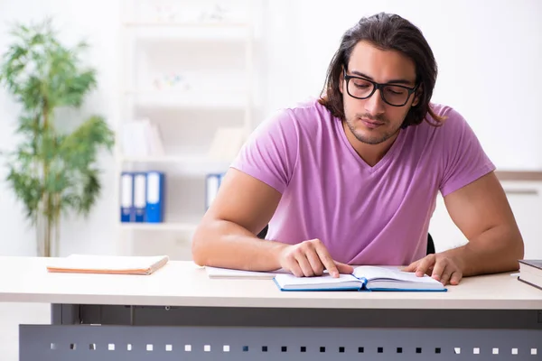 Ung manlig student förbereder sig för tentor i klassrummet — Stockfoto