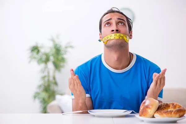 Joven hombre hambriento en concepto de dieta — Foto de Stock
