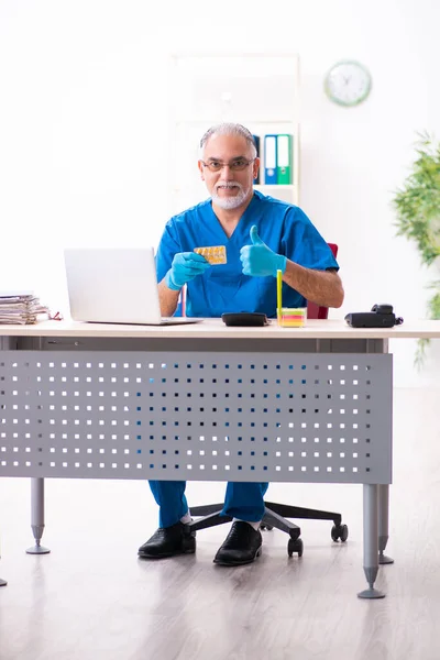 Alt männlich doktor apotheker working im die klinik — Stockfoto