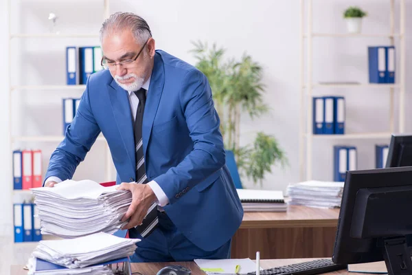 Velho empregado masculino e excesso de trabalho no escritório — Fotografia de Stock