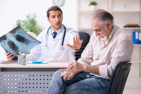 Ung manlig läkare och gammal patient i antirökningskoncept — Stockfoto