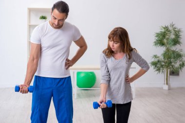 Kişisel koçla spor egzersizleri yapan genç bir kadın.