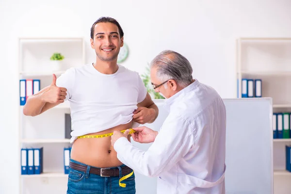 Médico dietista dando consejos a pacientes con sobrepeso de grasa — Foto de Stock