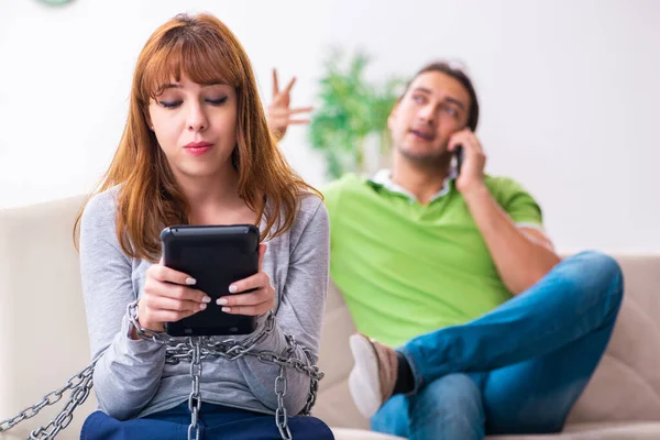 Pareja joven en concepto de dependencia gadget — Foto de Stock