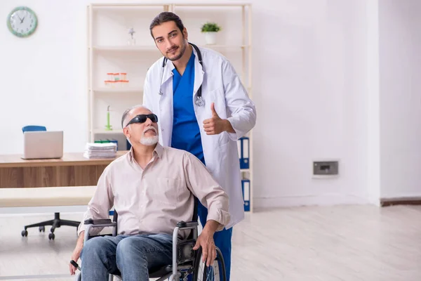 Oude blinde man op bezoek bij jonge mannelijke arts — Stockfoto