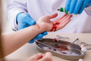 Yaralı kadın erkek doktoru ziyaret ediyor.