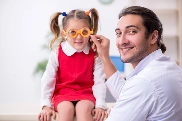 Klein meisje op bezoek bij jonge mannelijke arts oculist — Stockfoto