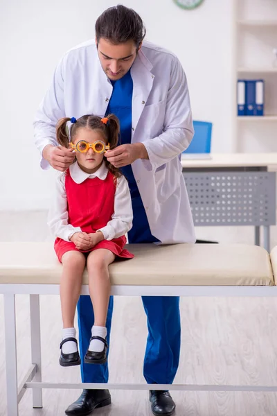 Menina pequena visitando jovem médico oculista masculino — Fotografia de Stock