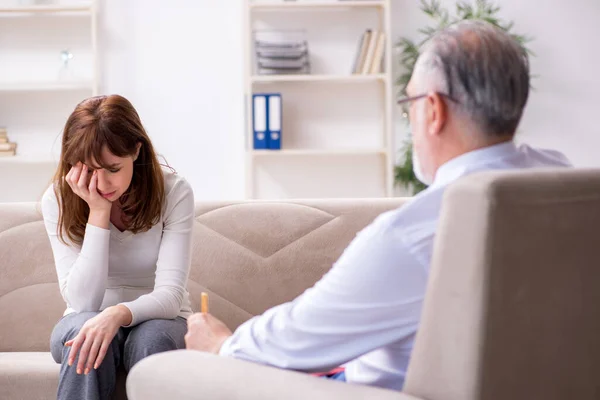 Junge Frau besucht alten Arzt-Psychologen — Stockfoto