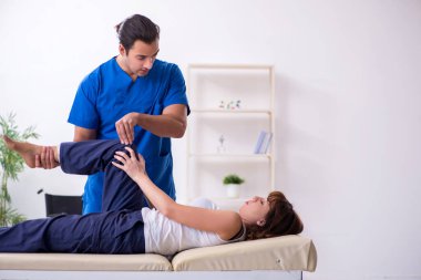 Yaralı kadın genç erkek doktor osteopat 'ı ziyaret ediyor.
