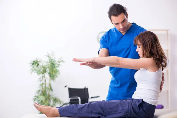 Mujer lesionada visitando al joven médico osteópata —  Fotos de Stock