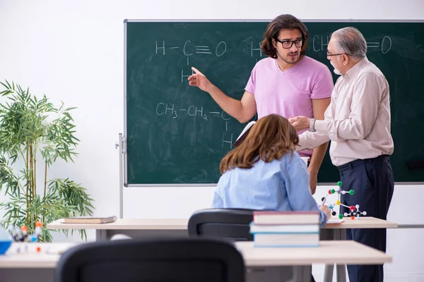 Oude scheikundeleraar en twee leerlingen in de klas — Stockfoto