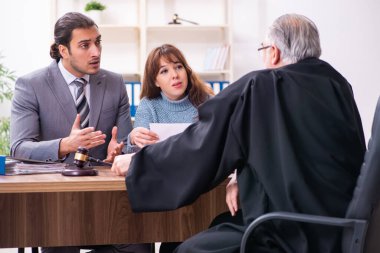 Yargıç ve avukatla birlikte adliyede genç bir kadın.