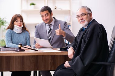 Yargıç ve avukatla birlikte adliyede genç bir kadın.