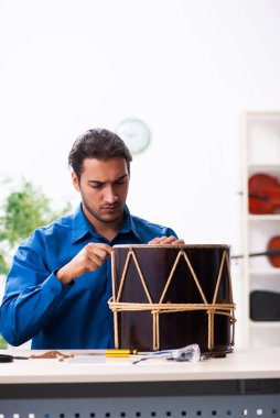 Davul tamir eden genç bir erkek tamirci.