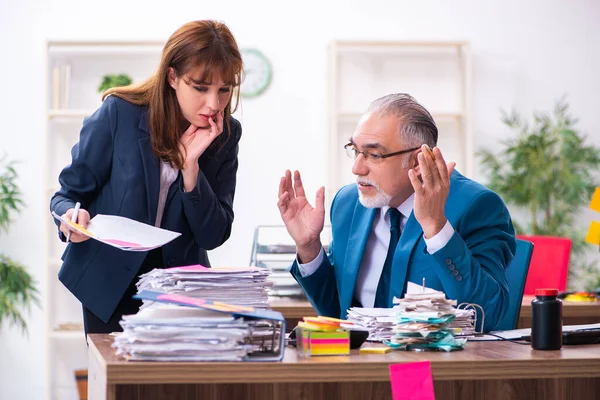 Dos empleados y trabajo excesivo en la oficina — Foto de Stock