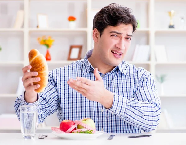 Az ember, akinek dilemmája van az egészséges étel és a diétás kenyér között — Stock Fotó