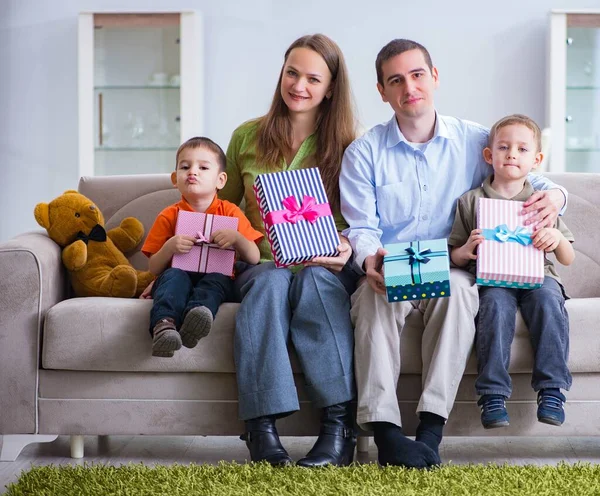 Padres jóvenes repartiendo regalos de Navidad en casa — Foto de Stock