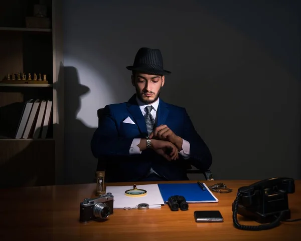 Detective sitting in dark room in vintage concept