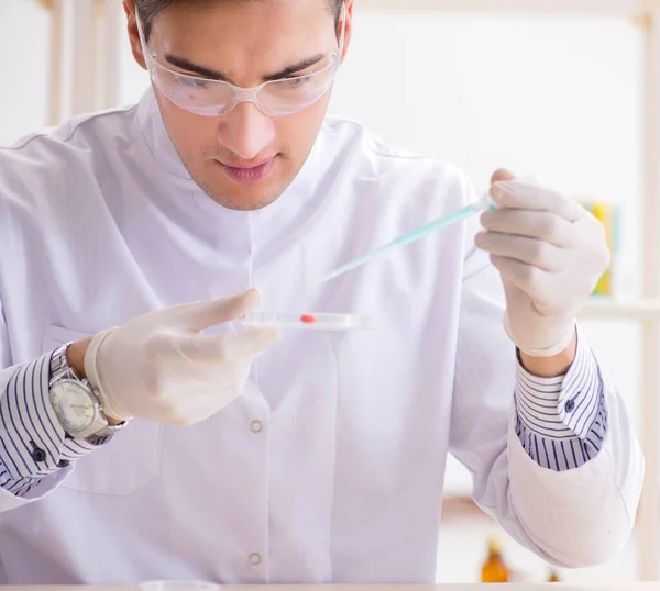 Jovem estudante de química que trabalha em laboratório em produtos químicos — Fotografia de Stock