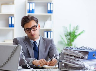 Ofis masasına zincirlenmiş meşgul bir çalışan.