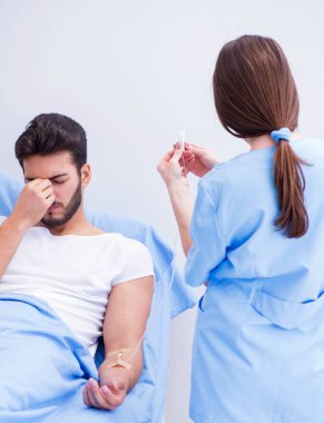 Kadın doktor erkek hastayı hastanede muayene ediyor.